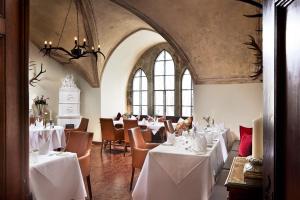 a dining room with white tables and chairs at Hotel Schloss Mittersill in Mittersill