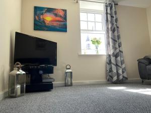 uma sala de estar com uma televisão de ecrã plano e uma janela em Winter Gardens North Pier 2 Bed em Blackpool