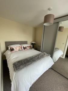 um quarto com uma cama grande com lençóis brancos e almofadas em Winter Gardens North Pier 2 Bed em Blackpool
