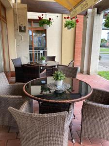 een patio met tafels, stoelen en planten bij Hotel Legend in Dunajská Streda