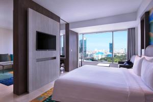 a hotel room with a bed and a television at Grand Mercure Jakarta Kemayoran in Jakarta