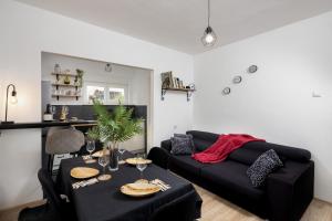 ein Wohnzimmer mit schwarzem Sofa und einem Tisch in der Unterkunft Wild in Sinj