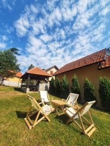 two lawn chairs and a table in the grass at Tara Apartmani Malešević - 2 in Bajina Bašta