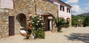 een stenen gebouw met bloemen ervoor bij La Colombera in Torrazza