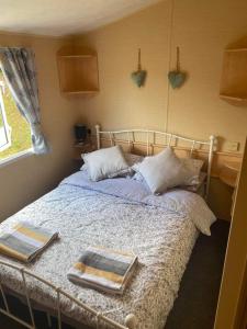 een slaapkamer met een bed met twee handdoeken erop bij Glade 34 in Bideford