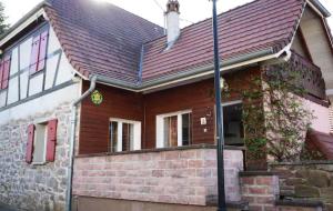 une maison avec un toit rouge et un mur en briques dans l'établissement gite du heidenberg, à Osenbach