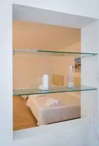 オートラントにあるホテル アルバニアのガラスの棚付きのベッドが備わる客室です。