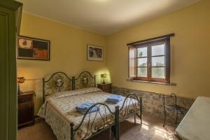 een slaapkamer met een bed en een raam bij Agriturismo Le Case Rosse di Montebuono in Magione