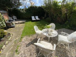 einen Tisch und Stühle in einem Garten mit Rasen in der Unterkunft Entire Edwardian Style Luxury Home in Broadstairs