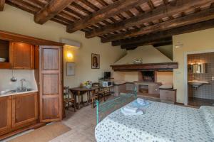 a living room with a bed and a kitchen at Agriturismo Le Case Rosse di Montebuono in Magione