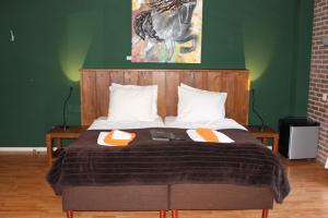 a bed with a wooden head board with two pillows at Boutique Hotel Nieuw Beusink in Winterswijk