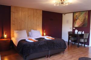 a bedroom with a bed with a desk and a table at Boutique Hotel Nieuw Beusink in Winterswijk