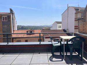 uma varanda com mesa e cadeiras no telhado em MONTECERRAO I (GARAJE Y WIFI GRATIS) em Oviedo