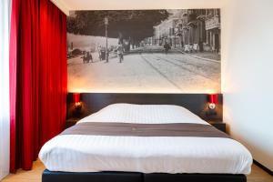 a bedroom with a large bed with red curtains at Bastion Hotel Utrecht in Utrecht