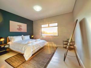 Un dormitorio con una cama grande y una ventana. en Turmalin Cottage Unit 2, en Swakopmund