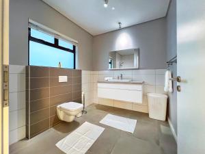 un baño con inodoro y lavabo en Turmalin Cottage Unit 2, en Swakopmund 31 fotos más