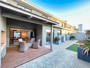 a house with a patio with chairs and a table at Turmalin Cottage Unit 2 in Swakopmund