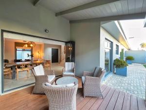 porche con sillas de mimbre y comedor en Turmalin Cottage Unit 2, en Swakopmund