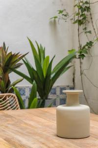 Casa Boma Lisboa - Design Apartment with Private Vegetal Terrace - Lapa VII في لشبونة: مزهرية بيضاء تجلس على طاولة خشبية