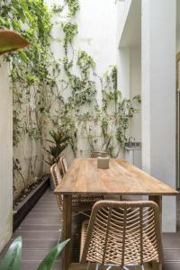 Casa Boma Lisboa - Design Apartment with Private Vegetal Terrace - Lapa VII في لشبونة: طاولة وكراسي أمام جدار بالنباتات