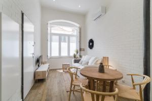 Casa Boma Lisboa - Design Apartment with Private Vegetal Terrace - Lapa VII في لشبونة: غرفة معيشة مع طاولة وأريكة