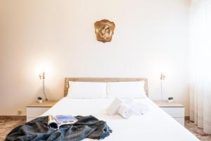 Un dormitorio con una cama blanca con libros. en Gardappartamenti Rivo lake view, en Desenzano del Garda