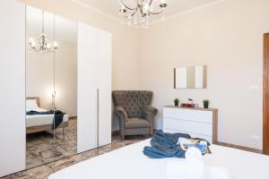 1 dormitorio con silla y espejo en Gardappartamenti Rivo lake view, en Desenzano del Garda