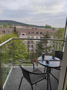 einen Tisch und Stühle auf einem Balkon mit Aussicht in der Unterkunft Blue Sky - apartament z pięknym widokiem na górę Telegraf in Kielce