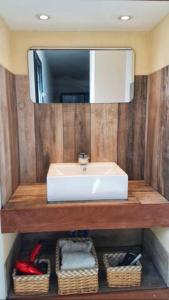 a bathroom with a sink and a mirror and baskets at Appartement neuf 3 chambres vue mer Propriano in Propriano