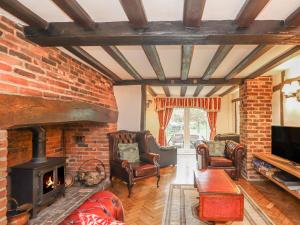 sala de estar con chimenea de ladrillo y sillas en Shepherd Cottages luxury self catering in heart of Kent, en Lenham