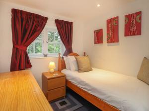 duas camas num quarto com cortinas vermelhas em Shepherd Cottages luxury self catering in heart of Kent em Lenham