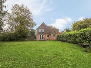 a house with a grass yard in front of it at Shepherd Cottages luxury self catering in heart of Kent in Lenham