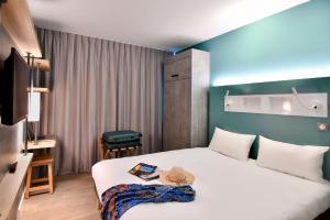 a hotel room with a bed with a hat on it at ibis budget Saint Nazaire Centre Gare in Saint-Nazaire