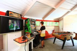 eine Person, die ein Videospiel in einem Raum spielt in der Unterkunft Village Nature et Océan à côté de la plage avec piscine et jacuzzi in Messanges