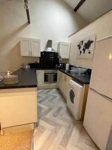 cocina con nevera, lavadora y secadora en Flat 2 Chestergate, en Macclesfield