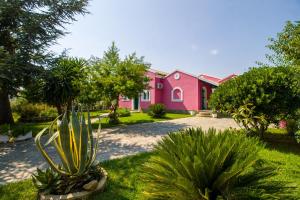 una casa rosa con piante davanti di Casa Andriana a Vragkaniótika