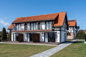 a large white house with an orange roof at W Starym Porcie Krynica Morska in Krynica Morska