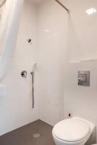 a white bathroom with a toilet and a shower at Oַ&O Group-Amazing APT Bat-Yam 3 Min Walk To Beach in Bat Yam