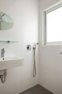 a white bathroom with a sink and a mirror at Oַ&O Group-Amazing APT Bat-Yam 3 Min Walk To Beach in Bat Yam