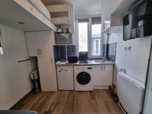 a small kitchen with a washing machine and a sink at Amazing Studio near Parc des Expositions in Paris