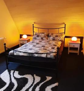 a bedroom with a bed with two nightstands and two lamps at FEWO im alten Bahnhof in Niederroßbach