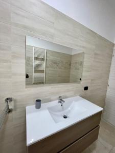 uma casa de banho com um lavatório branco e um espelho. em B&B La Piazzetta em Fragagnano