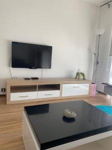 sala de estar con TV de pantalla plana en un centro de entretenimiento de madera en Ferienwohnung bei den Externsteinen, en Horn-Bad Meinberg