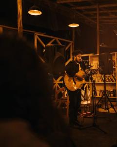a man playing a guitar on a stage at Jungle by sturmfrei Manali in Manāli