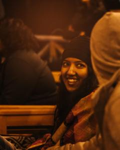 a woman sitting in a theatre smiling at the camera at Jungle by sturmfrei Manali in Manāli