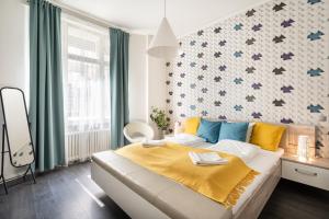 a bedroom with a large bed with yellow and blue pillows at BpR Lavish Suite in Budapest Downtown in Budapest