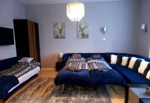un soggiorno con divano blu e letto di Blanka Villa Wellness Home a Bakonyszentlászló