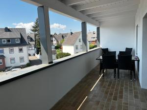 a balcony with a table and chairs and windows at Hotel Heimatherz in Rheinböllen