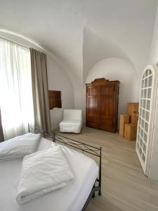 a bedroom with a bed with white sheets and a window at Verdepiano Bed & Camping in Riva del Garda +95 photos