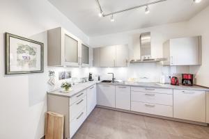 a white kitchen with white cabinets and a sink at Landidylle in Sembzin in Sembzin
